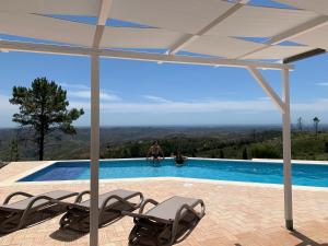 a man sitting on the edge of a swimming pool at Quinta O Ninho in Monchique