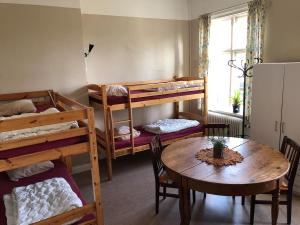 a room with bunk beds and a table and a dining room at Nyköpings Vandrarhem in Nyköping