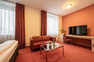 a hotel room with a couch and a television at Ruby Blue in Ostrava