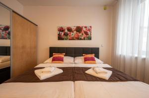 a bedroom with a large bed with towels on it at Ruby Blue in Ostrava
