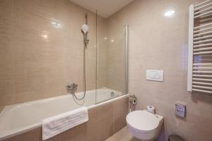 a bathroom with a tub and a toilet and a sink at Ruby Blue in Ostrava