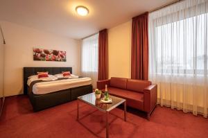 a hotel room with a bed and a couch and a table at Ruby Blue in Ostrava