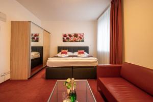 a bedroom with a bed and a couch and a table at Ruby Blue in Ostrava