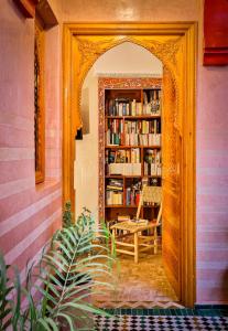 une arche dans une bibliothèque avec une table et une chaise dans l'établissement RIAD VILLA SIDI BABA, à Marrakech