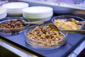 a counter topped with trays of food on a table at Ruby Blue in Ostrava