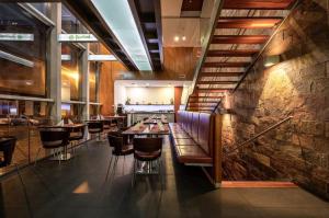 a restaurant with wooden tables and chairs and a staircase at Ruby Blue in Ostrava