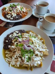 una mesa con platos de comida y tazas de café en Hotel Ankara "Las Lomas" en San Luis Potosí