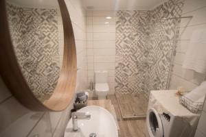La salle de bains est pourvue de toilettes et d'une douche avec un miroir. dans l'établissement Stavros boutique apartments 2, à Leucade