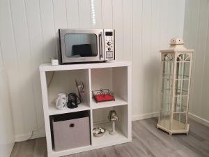 um micro-ondas sentado em cima de uma prateleira branca em Bårdshaug studio apartment em Orkanger