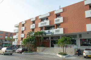 un edificio de ladrillo rojo con palmeras delante en Ayenda 1313 Barahona 72, en Barranquilla