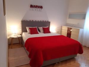 um quarto com uma cama vermelha e branca com um cobertor vermelho em Apartment Jardin em Zadar