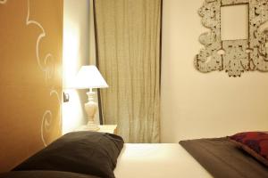 a bedroom with a bed and a lamp and a mirror at Parmigianino Nove in Parma