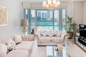 a living room with a couch and a chandelier at Elite Royal Apartment - Full Bujr Khalifa & Fountain View - Senator - 2 bedrooms & 1 open bedroom without partition in Dubai