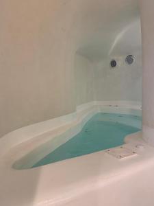 a bath tub sitting in a bath room at Chic Hotel Santorini in Firostefani