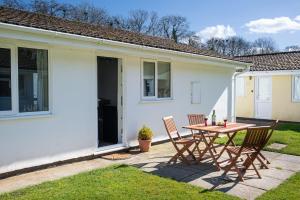 a patio with a table and chairs in front of a house at The Burrow in Liskeard