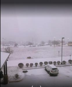 un coche aparcado en un aparcamiento cubierto de nieve en Days Inn by Wyndham Indiana Benjamin Franklin Highway, en Indiana