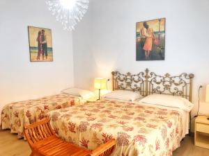 a bedroom with two beds and a chandelier at Appartamenti Tina Paolini 1 piano terra con parcheggio in Castiglione della Pescaia