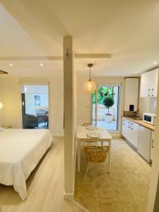 a bedroom with a bed and a table and a kitchen at Feel@Home Nemausus « Le 11 » in Nîmes