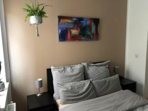 Un dormitorio con una cama con una pintura encima. en Gemütliche 2 Zimmer Wohnung neben der Burg en Kröllwitz