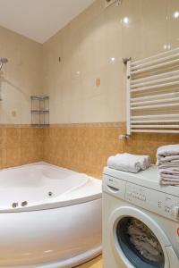 a bathroom with a washing machine and a tub at Ekaterina Apartments - Odessa in Odesa