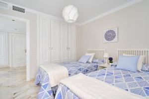 two beds in a room with blue and white at Apartamento Málaga City Beach in Málaga