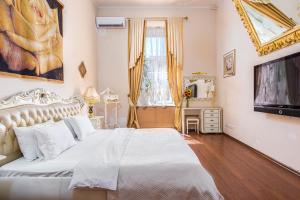a bedroom with a white bed and a television at Ekaterina Apartments - Odessa in Odesa