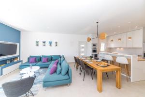 een woonkamer met een blauwe bank en een tafel bij Villa Olivia Trogir in Trogir