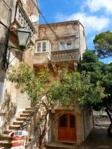 Edificio antiguo con puerta roja y balcón en Sorelle apartment, en Korčula