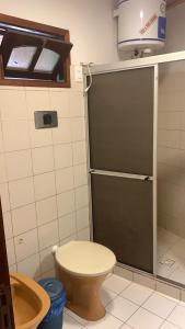 a bathroom with a toilet and a sliding door at Cabañas Marcelo in Barra del Chuy