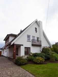 a white house with a balcony and a yard at Vakantiehuis Elisa in Alken