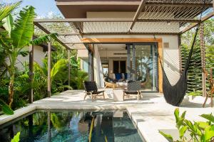 a villa with a swimming pool and a house at Hotel Nantipa - A Tico Beach Experience in Santa Teresa Beach