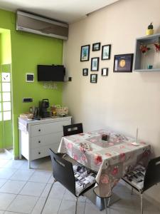 a dining room with a table and chairs and green walls at Casa vacanza dei Greci in Barletta