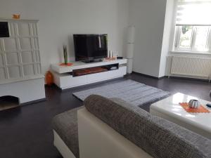 a hotel room with a bed, television and a desk at Green Hill Apartments - Feldkirch in Feldkirch