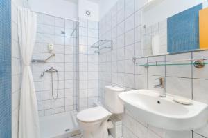 a white bathroom with a toilet and a sink at Kohylia by La Scala Beach in Limenas