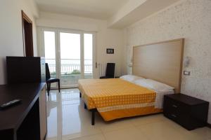 a hotel room with a bed and a large window at Hotel Residence Villa Jolanda in Lido di Camaiore