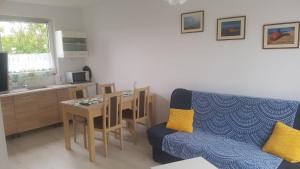 a living room with a table and a blue couch at DOMKI "apartamenty 4maki" in Jastrzębia Góra