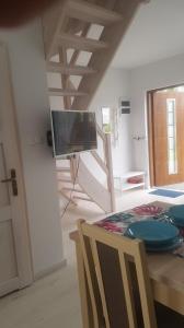 a living room with a table and a tv on the wall at DOMKI "apartamenty 4maki" in Jastrzębia Góra