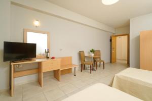a room with a desk with a television and a table at Kohylia by La Scala Beach in Limenas