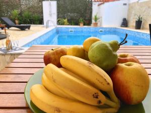 ザダルにあるVilla Sanda with Private Poolのプールサイドのテーブルに盛られた果物