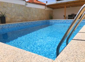 ザダルにあるVilla Sanda with Private Poolの家の中のブランコ付き青いスイミングプール