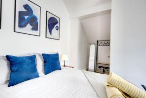 a bedroom with a white bed with blue pillows at Modern Comfort-Family-friendly-Near City & Peaks in Sheffield