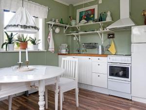 a kitchen with a white table and a white refrigerator at 2 person holiday home in RIMFORSA in Rimforsa