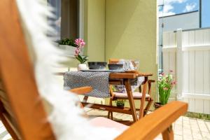 einen Tisch und Stühle auf einem Balkon mit Blumen in der Unterkunft Apartmán Dream v Mikulově - Jiné ubytování Lednice in Mikulov