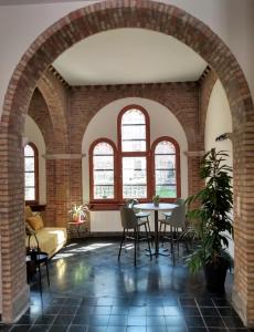 - un salon avec une table, des chaises et des fenêtres dans l'établissement Pilgrim's Loft, à Ypres