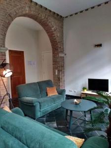 uma sala de estar com um sofá azul e uma mesa em Pilgrim's Loft em Ypres