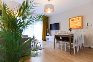 Una sala de estar y un comedor con mesa y sillas. en M&K Apartament Moc Natury Sobieszewo - Wyspa Sobieszewska, en Gdansk