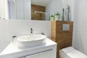 Un baño blanco con lavabo e inodoro. en M&K Apartament Moc Natury Sobieszewo - Wyspa Sobieszewska, en Gdansk 35 fotos más
