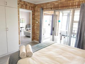 a bedroom with a bed and a brick wall at Surf Point 7 in Jeffreys Bay