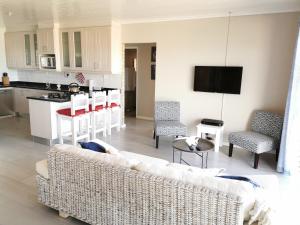 a living room with a couch and a kitchen at Surf Point 7 in Jeffreys Bay
