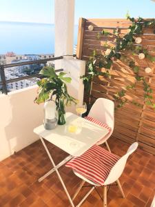 トレモリノスにあるSailor Apartmentsの白いテーブルとバルコニー(椅子2脚付)